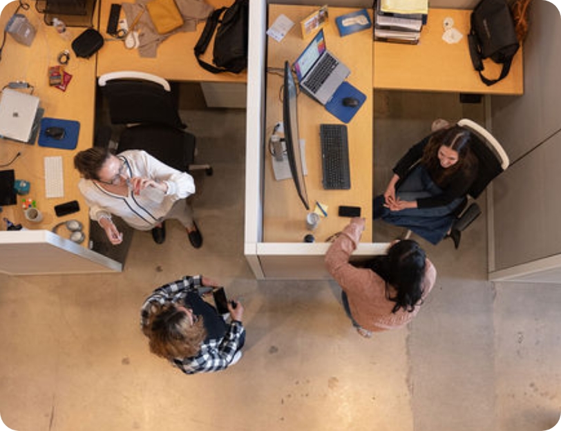 A photo taken from a bird’s-eye perspective shows several employees in the Replicate office.